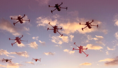 Group of surveillance drones in front  with sunset sky scene background
