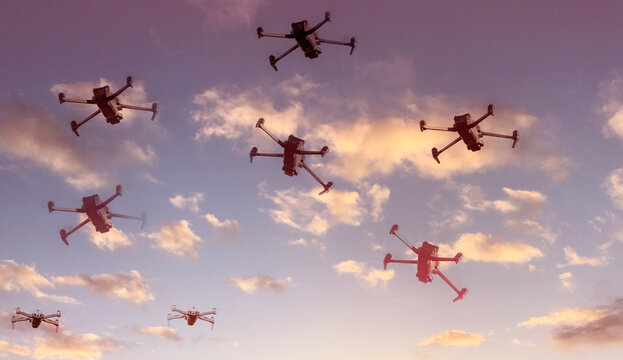 Group of surveillance drones in front  with sunset sky scene background