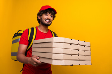 Happy deliveryman wearing a red uniform holding pizza boxes with a bright yellow background emphasizing vibrant style