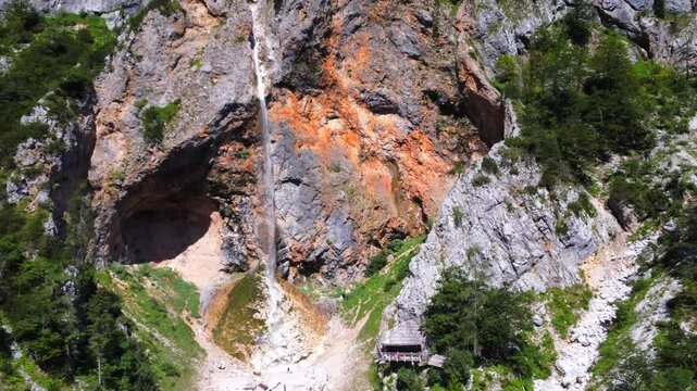 Aerial view capturing rinka waterfall cascading into the scenic logarska dolina valley, surrounded by lush greenery and rocky cliffs