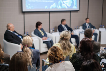 Fototapeta premium Audience attending panel discussion with professional speakers sharing insights on business trends and strategies
