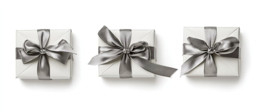 Elegant gift boxes with silver ribbons and bows arranged on a white background viewed from above for festive and celebration themes