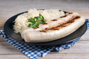 Bratwurst sausage and sauerkraut on wooden table