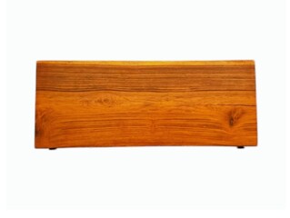 In the picture is a brown wooden table made from a single piece of beautiful golden teak wood with a black steel frame with a floral pattern on all four sides used as the base of the table.