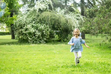 Happy child running in green park enjoying springtime