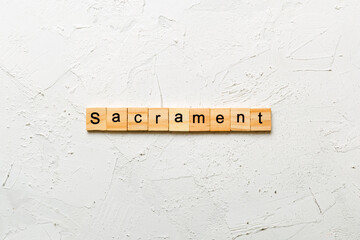 sacrament word written on wood block. sacrament text on table, concept