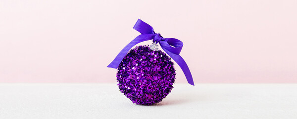 Christmas ball on colored background. decoration bauble with ribbon bow with copy space