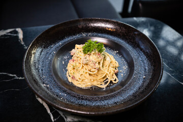 Spaghetti carbonara on the black plate