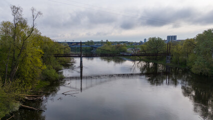 Obraz premium Tranquil River with Bridge and Lush Greenery