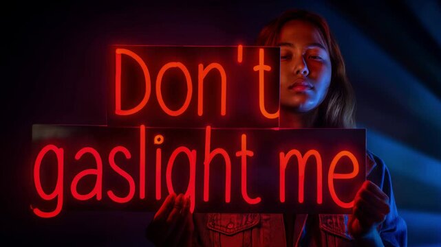 Don't gaslight me glowing neon sign held by Young woman in a dark room. Concept manipulation in abusive relationships with a narcissist partner or toxic co-worker.