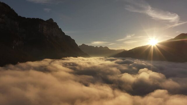 Golden sunrise over misty clouds and mountains in Walensee, Switzerland