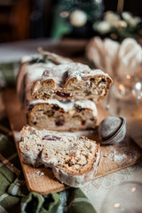 Christmas stollen decorated with a cinnamon stick on a festive table, Scandinavian style, Scandinavian Christmas, stollen with powdered sugar, raisins, candied fruits