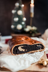 Poppy seed roll on the festive table, Scandinavian style, Scandinavian Christmas, candles, Christmas tree