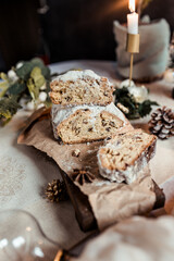 Christmas stollen decorated with a cinnamon stick on a festive table, Scandinavian style, Scandinavian Christmas, stollen with powdered sugar, raisins, candied fruits