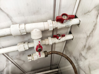 Pipes and valves in a residential utility area showing plumbing installation and maintenance work