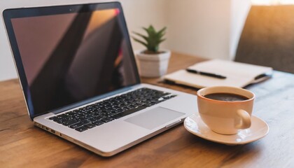 Fototapeta premium Open Laptop with a Cup of Coffee and a Notebook on a Wooden Desk in a Cozy and Minimalist Home Office