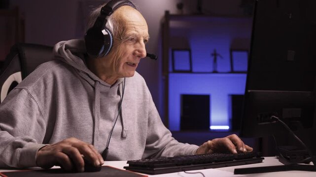 elderly pensioner man playing online games using pc gaming setup having a good time in home living room emotion of disappointment throwing up hands in frustration indignant