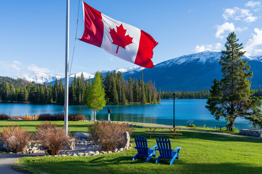 Canadian flag and mountains and trees. Jasper National Park summer landscape. Lac Beauvert Trail (Beauvert Lake).
