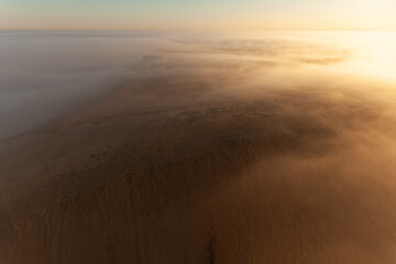 Tower lookout with beautiful sunrise at Lighthouse of Rubjerg Knude. Denmark north coast with wonderfully illuminated fog.