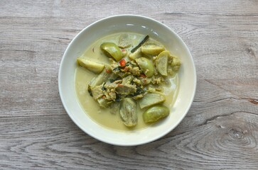 spicy boiled slice beef meat with eggplant in coconut milk green curry soup on plate
