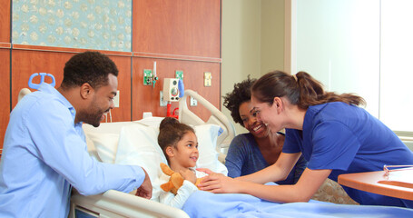 Obraz premium Close Up Of Female Doctor Or Nurse With Soft Toy Meeting Parents Visiting Daughter In Hospital Bed