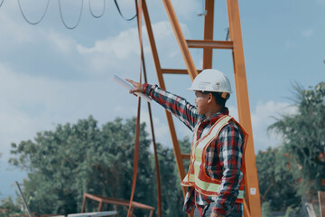 Asian male engineer standing inspecting work outdoors