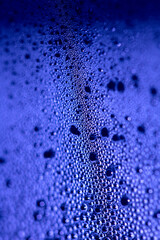 Close Up of Condensation Floating Liquid Water Bubbles and Drips on Glass from Rain