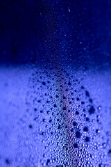 Close Up of Condensation Floating Liquid Water Bubbles and Drips on Glass from Rain