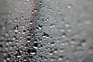 Close Up of Condensation Floating Liquid Water Bubbles and Drips on Glass from Rain