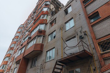 Fototapeta premium Russian missile hits residential building in Dnipro, Ukraine. Aftermath of enemy attack on city. Destroyed residential multi-story building. Close-up. War. Aftermath of explosion.