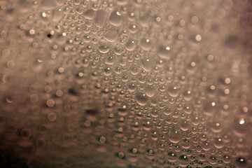 Close Up of Condensation Floating Liquid Water Bubbles and Drips on Glass from Rain