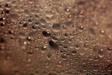 Close Up of Condensation Floating Liquid Water Bubbles and Drips on Glass from Rain