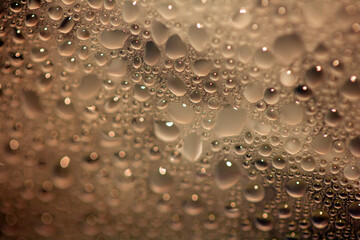 Close Up of Condensation Floating Liquid Water Bubbles and Drips on Glass from Rain