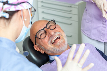 Senior man laughing during dental checkup at clinic