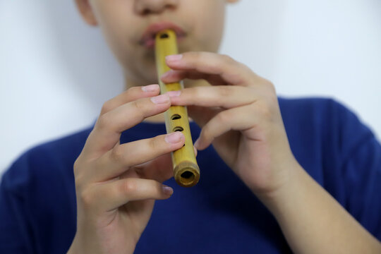 Close-up of boy playing the Indian flute. Wind instrument from the Latin American highlands. Music	
