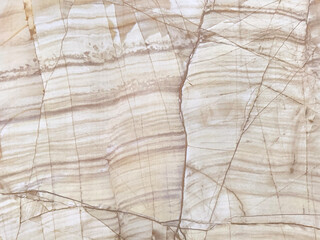 Close up of beige yellow natural marble slab texture. Light yellow cream marble with dark brown veins and random cut, seamless wall panel background texture.