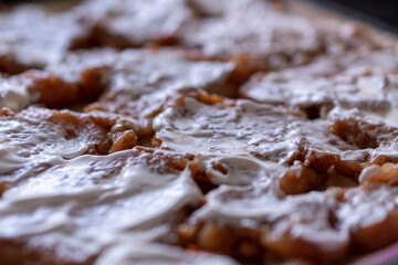 Fried chicken fillet with pineapple and cheese on a dark baking sheet