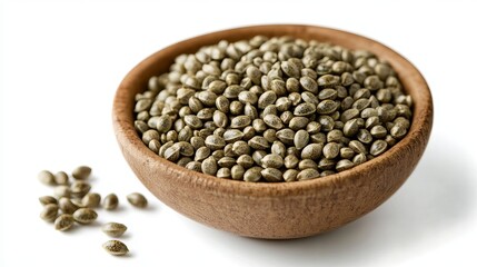 Obraz premium Hemp Seeds: A small bowl of raw hemp seeds with a pale green color, isolated against a white background. 