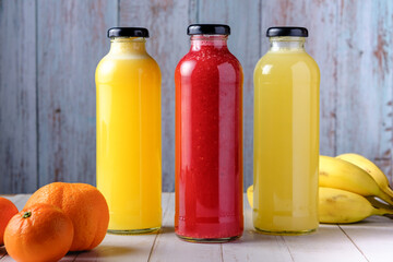 jugos naturales diferentes colores en envases vidrio.