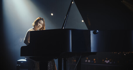 Female Composer Pours Her Soul Into the Grand Piano, Filling the Venue With Expressive Notes. Stage...