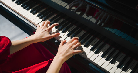 Fototapeta premium Close Up on Hands of a Talented Anonymous Pianist Making a Masterful Performance on a Grand Piano. Under Soft Stage Lights, Female Fingers Move Across the Keys, Creating Beautiful Classical Music