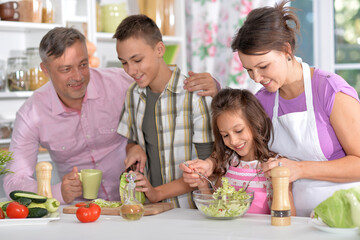 Portrait of beautiful family cooking at kitchen