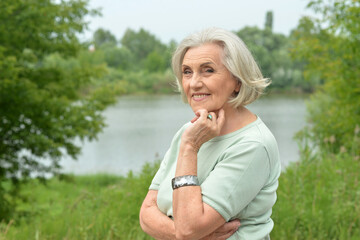 Fototapeta premium Portrait of a beautiful elderly woman in the park