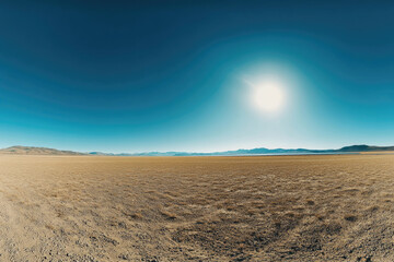 Fototapeta premium Vast, arid landscape under a bright sun, featuring distant mountains and a dry, flat terrain.