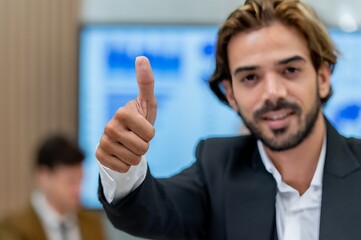 Businessman giving thumbs up in a meeting