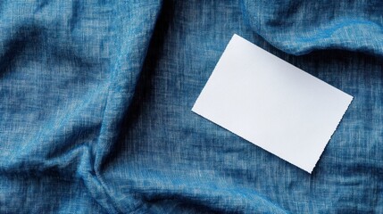 White Blank Laundry Care Label on Blue Shirt Fabric Background
