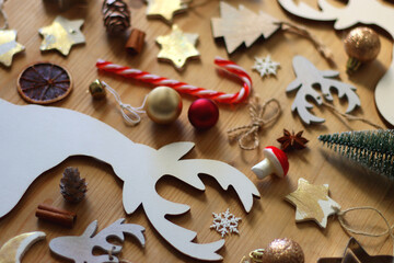 Various Christmas decorations in neutral colors on wooden background. Selective focus.
