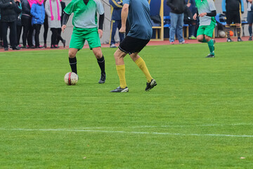 Two soccer players on a football field during an attack by one of the teams, close-up of the players' tactical actions during a soccer match, development of an attack in football.