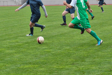 Football players with the ball on the football field, a soccer player with the ball against defenders