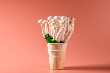 shimeji mushrooms with green moss in an ice cream cone, on bright, colorful, pink background